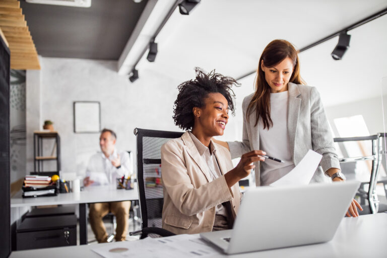 woman showing something to another colleague.