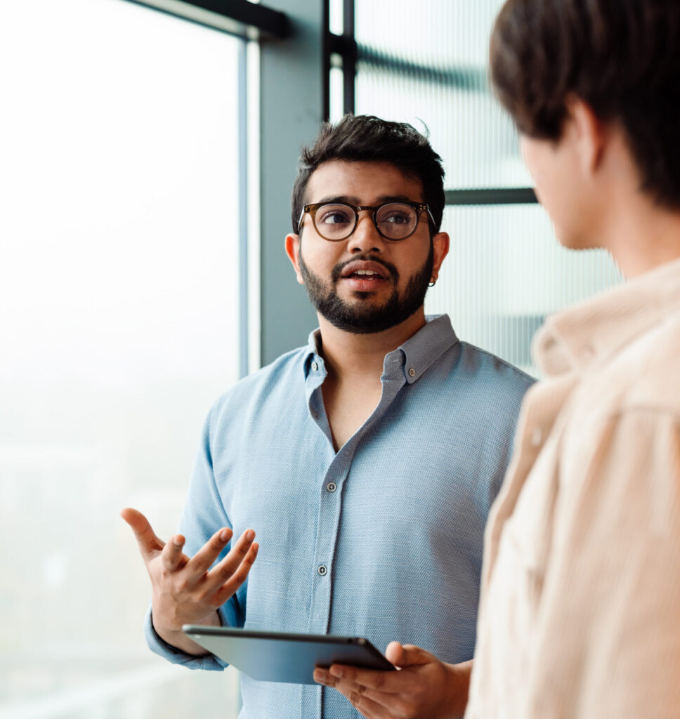 two male colleagues discussing project during meeting in office